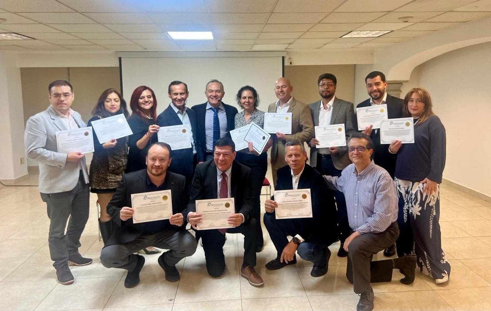Generación de egresados sosteniendo su certificado de Meta-Coaching.